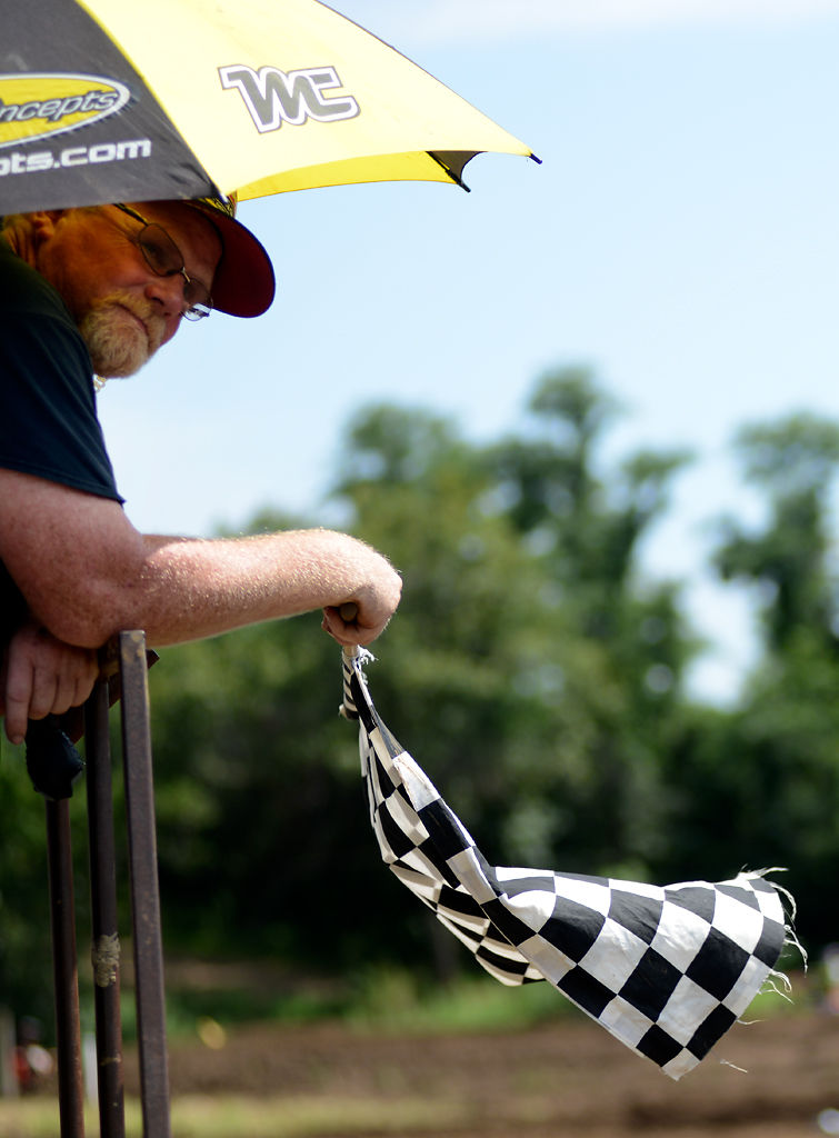 Finish line flagger Kenny Hulsey waves the checkered flag at the end of the race